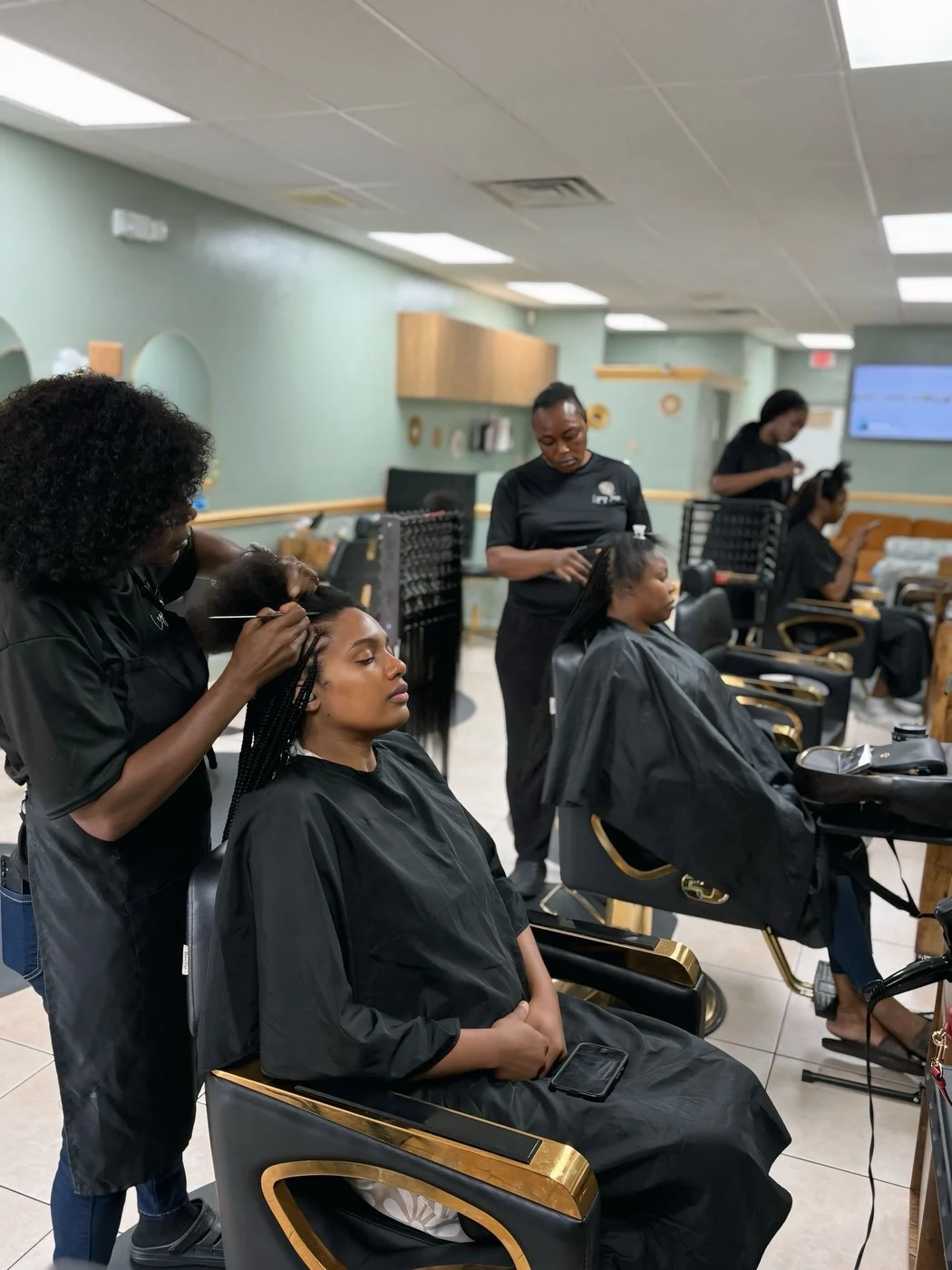 Braiders at work on the LegacyTress salon floor